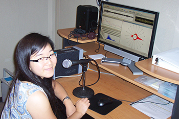 Student using a microphone at a computer.